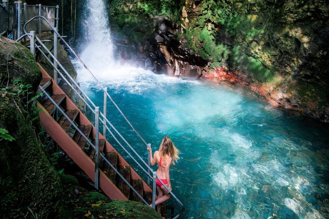 Girl taking a shower in Esmeralda Waterfalls - Rincón de la Vieja National Park - Costa Rica.