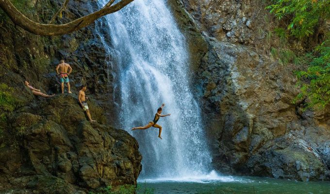 Woman junping in the Montezuma Waterfall - Costa Rica